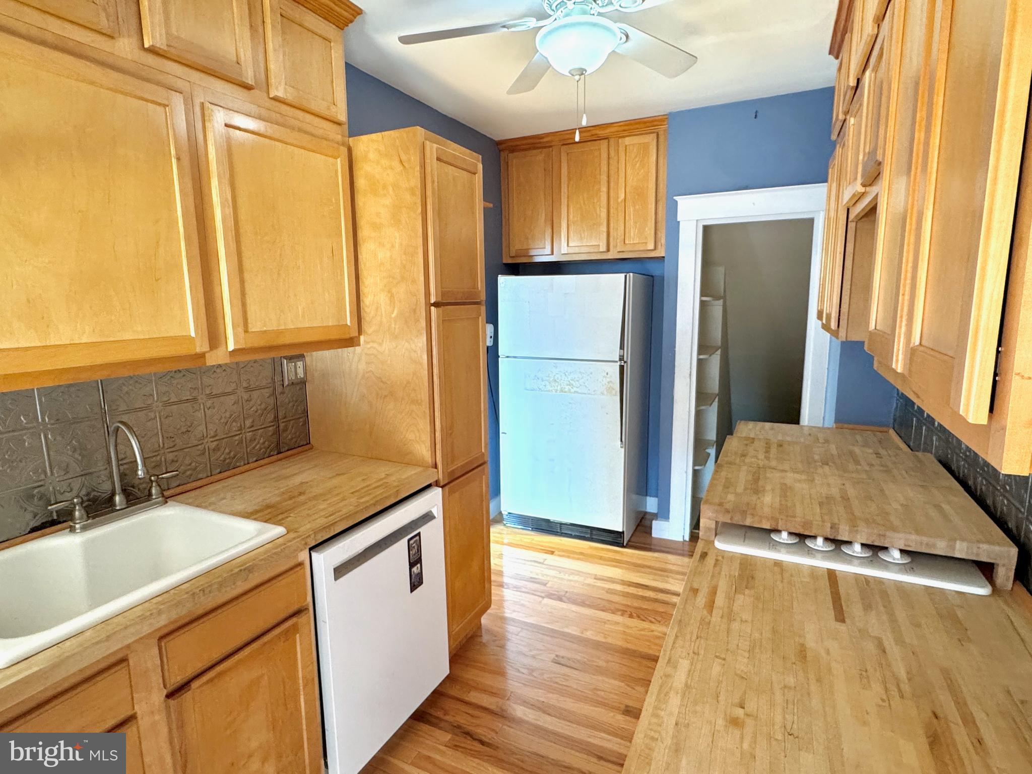 331 Sunset Road Reading, PA 19611 - Photo 9 of 32 a kitchen with stainless steel appliances granite countertop a sink a refrigerator cabinets and wooden floor