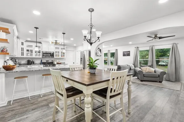 a view of a dining room and livingroom with furniture wooden floor a chandelier