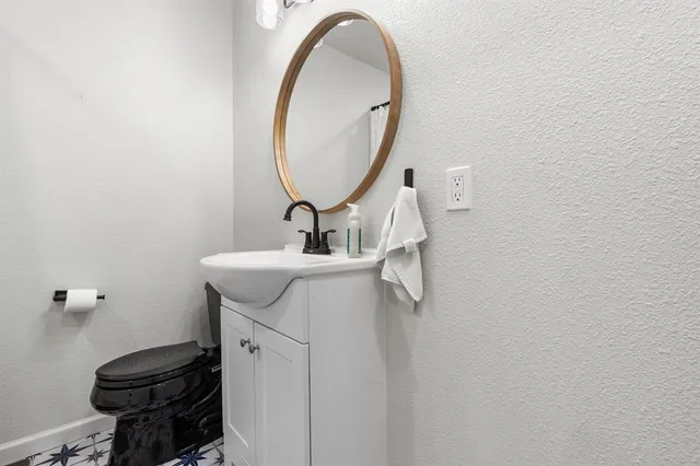 a bathroom with a sink toilet and a mirror