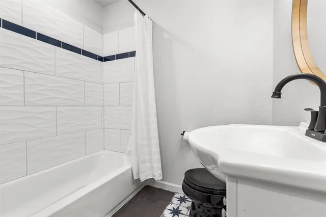 a bathroom with a sink a toilet and bathtub