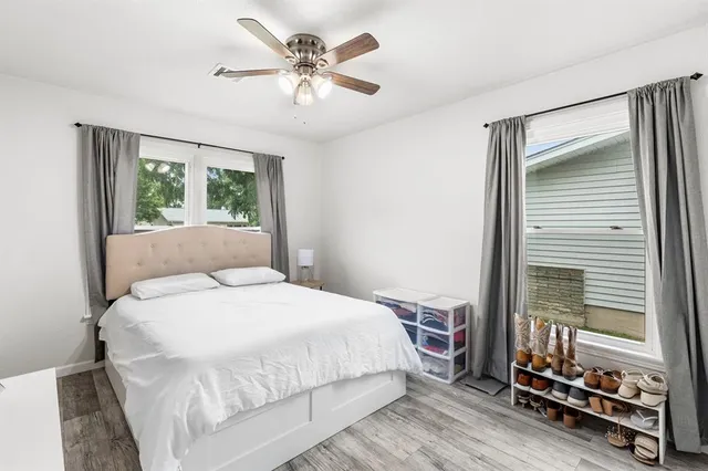 a bedroom with a bed and a large window with chair