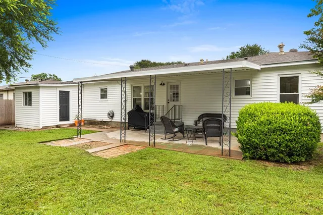 a view of a house with backyard and a sitting area