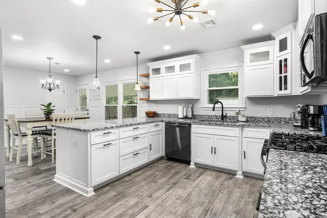 a kitchen with kitchen island granite countertop a sink cabinets and stainless steel appliances