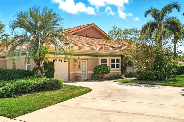 a front view of a house with a yard and potted plants