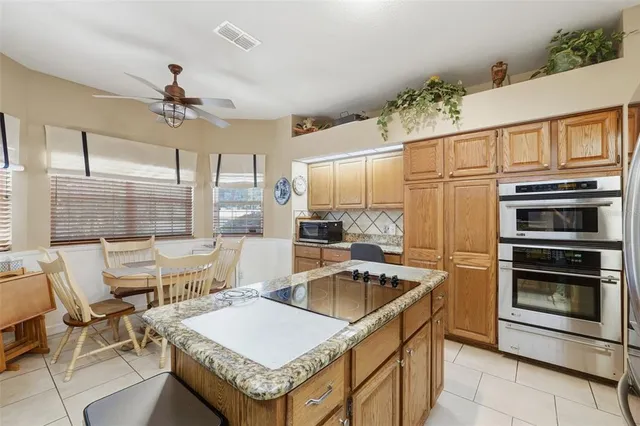 a kitchen with a table chairs stainless steel appliances and cabinets