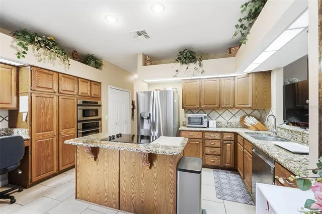 a large kitchen with kitchen island granite countertop a sink counter space and cabinets