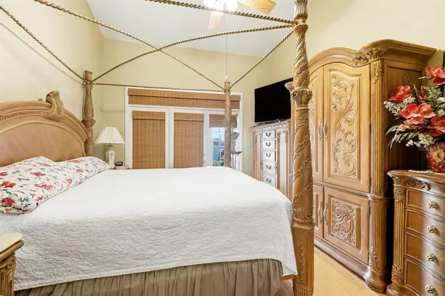 a bedroom with a bed a flat screen tv and dresser