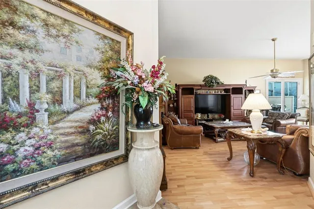 a living room with furniture a flowers and a flat screen tv
