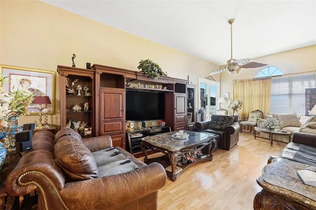 a living room with furniture a flat screen tv and a floor to ceiling window