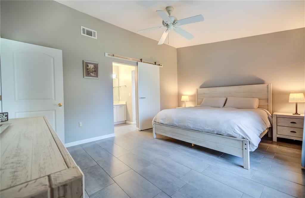 600 Carriage House Lane, Unit 201 Nokomis, FL 34275 - Photo 12 of 23 a bedroom with a bed and a chandelier