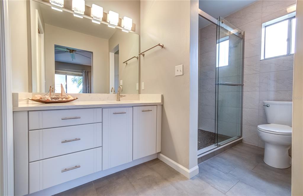 600 Carriage House Lane, Unit 201 Nokomis, FL 34275 - Photo 13 of 23 a bathroom with a toilet a sink and mirror