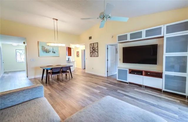 a living room with furniture a dining table chairs and a chandelier
