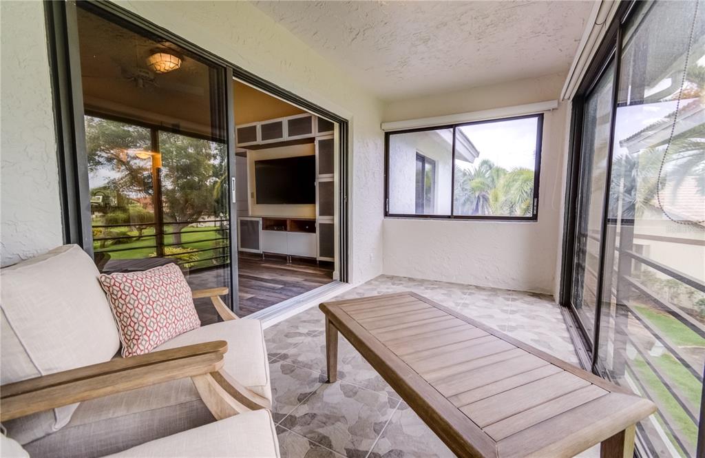 600 Carriage House Lane, Unit 201 Nokomis, FL 34275 - Photo 9 of 23 a living room with furniture and a flat screen tv