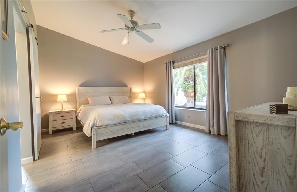 600 Carriage House Lane, Unit 201 Nokomis, FL 34275 - Photo 10 of 23 a bedroom with a bed and a chandelier