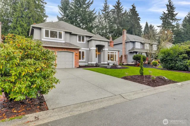 a front view of a house with a yard and potted plants