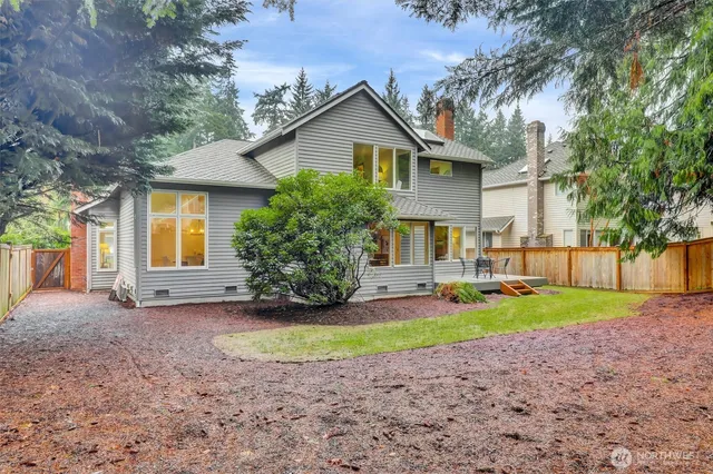 a view of a house with a yard and large tree