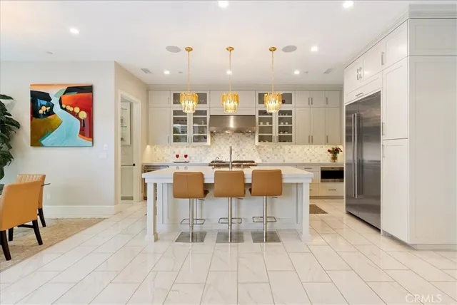 a dining hall with stainless steel appliances kitchen island granite countertop a dining table and chairs