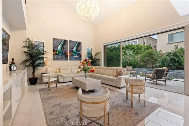a living room with couches and a large mirror with potted plants