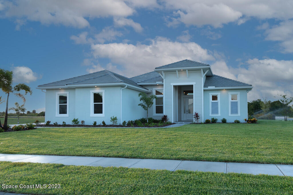 3940 Domain Court Melbourne, FL 32934 - Photo 1 of 27 a front view of a house with a yard and garage