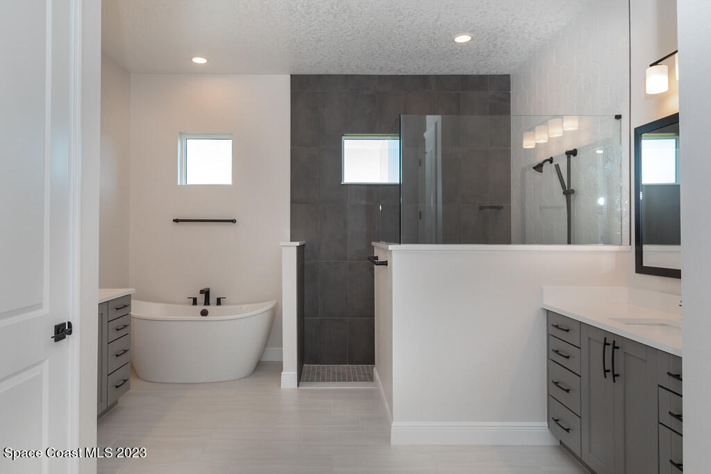 3940 Domain Court Melbourne, FL 32934 - Photo 11 of 27 a spacious bathroom with a double vanity sink mirror and bathtub