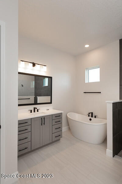 3940 Domain Court Melbourne, FL 32934 - Photo 12 of 27 a spacious bathroom with a double vanity sink mirror and bathtub