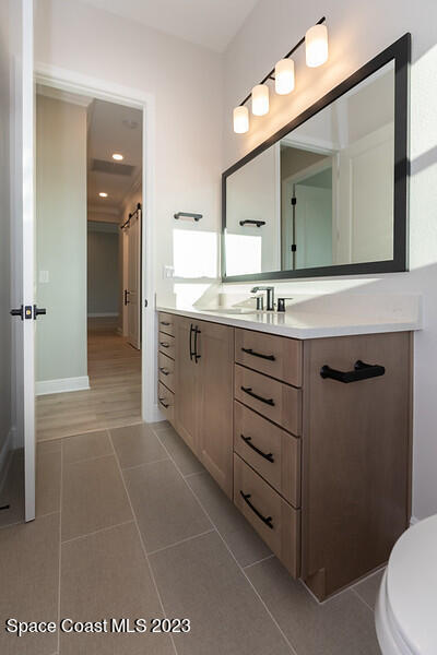 3940 Domain Court Melbourne, FL 32934 - Photo 22 of 27 a bathroom with a sink a toilet and mirror