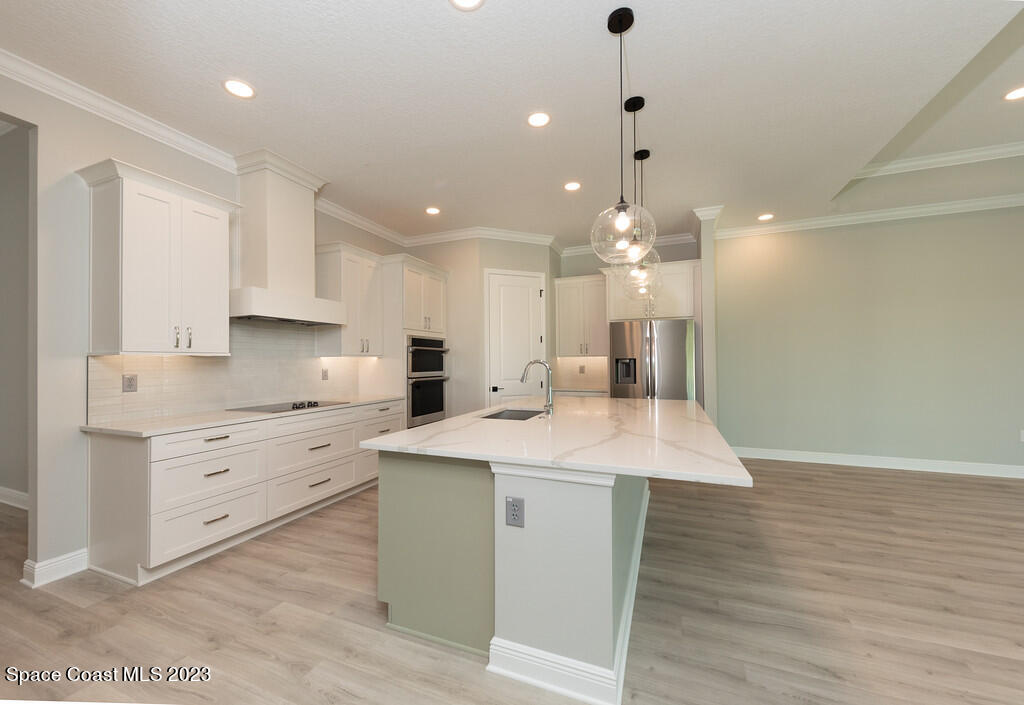 3940 Domain Court Melbourne, FL 32934 - Photo 6 of 27 a kitchen with kitchen island a sink stainless steel appliances and cabinets