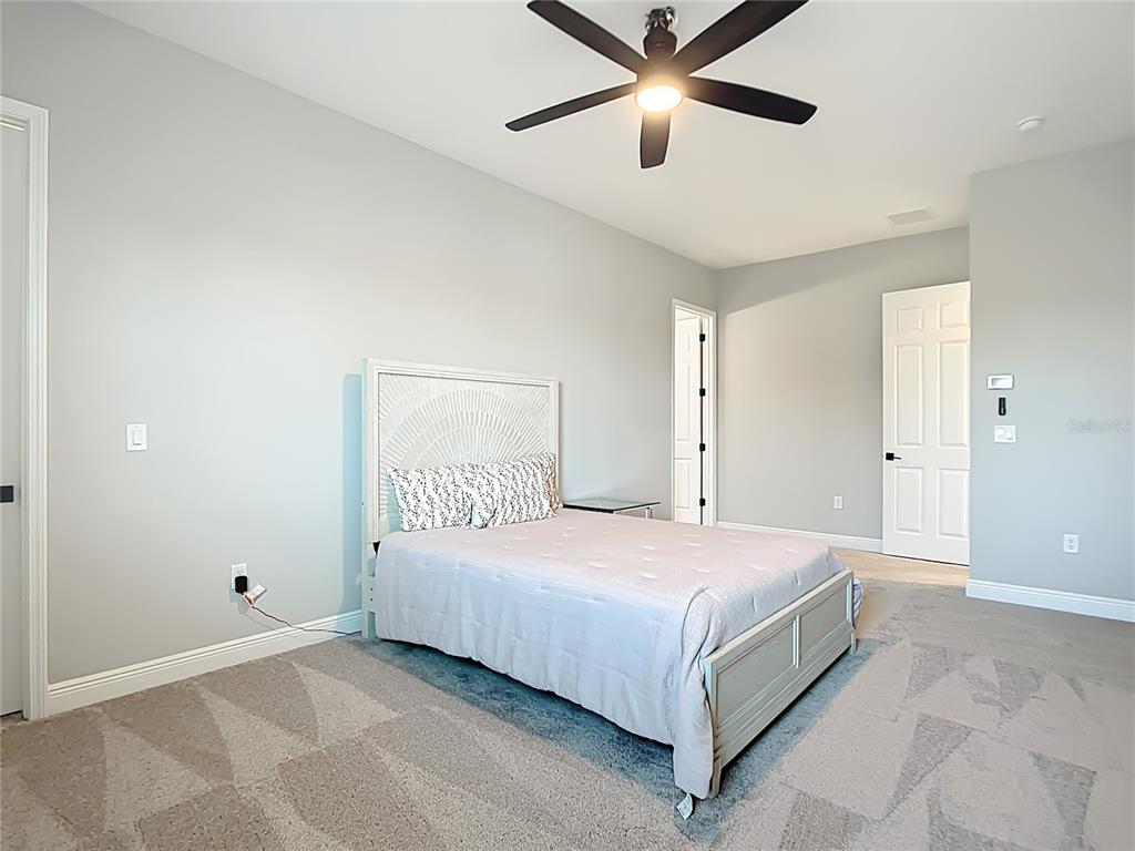 3586 Recurve Circle Sarasota, FL 34240 - Photo 39 of 65 a bedroom with a large bed and a chandelier