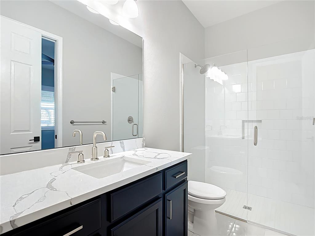 3586 Recurve Circle Sarasota, FL 34240 - Photo 39 of 66 a bathroom with a sink a toilet a shower and a mirror