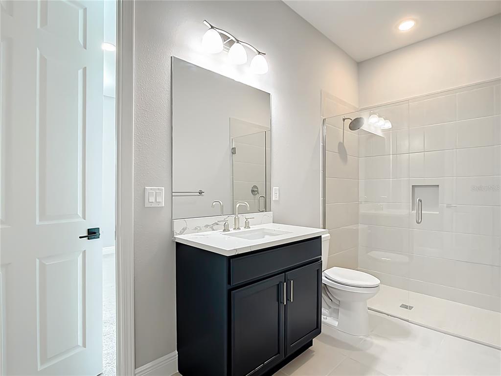 3586 Recurve Circle Sarasota, FL 34240 - Photo 44 of 66 a bathroom with a sink a toilet a mirror and shower