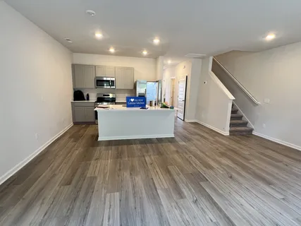 a view of a kitchen with wooden floor and electronic appliances