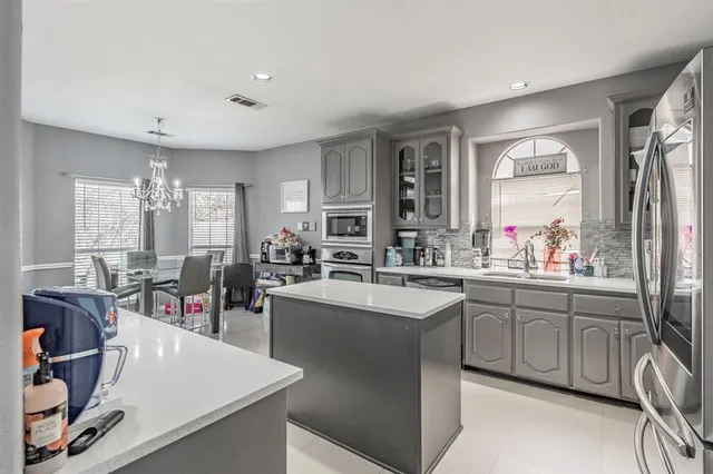 a large kitchen with lots of counter space sink and a refrigerator