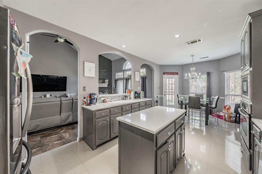 5243 West Cove Way Grand Prairie, TX 75052 - Photo 38 of 38 a kitchen with a stove a refrigerator and a dining table