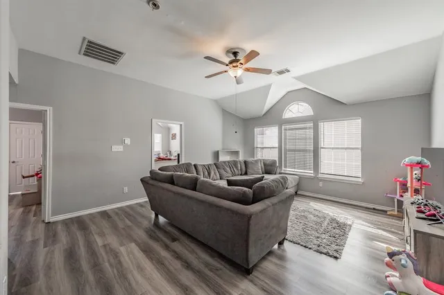 a living room with furniture and a wooden floor