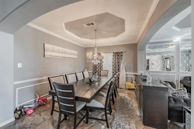 a view of a dining room with furniture and chandelier