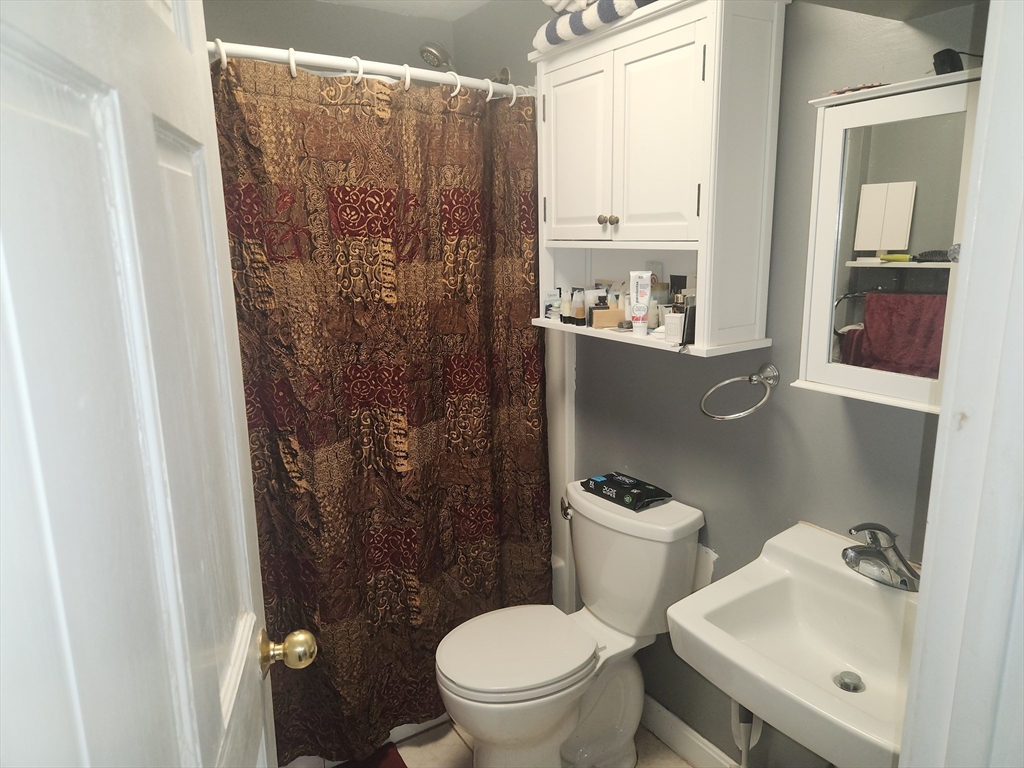 81 Cabot Street, Unit 1M Beverly, MA 01915 - Photo 3 of 13 a bathroom with a toilet sink and mirror