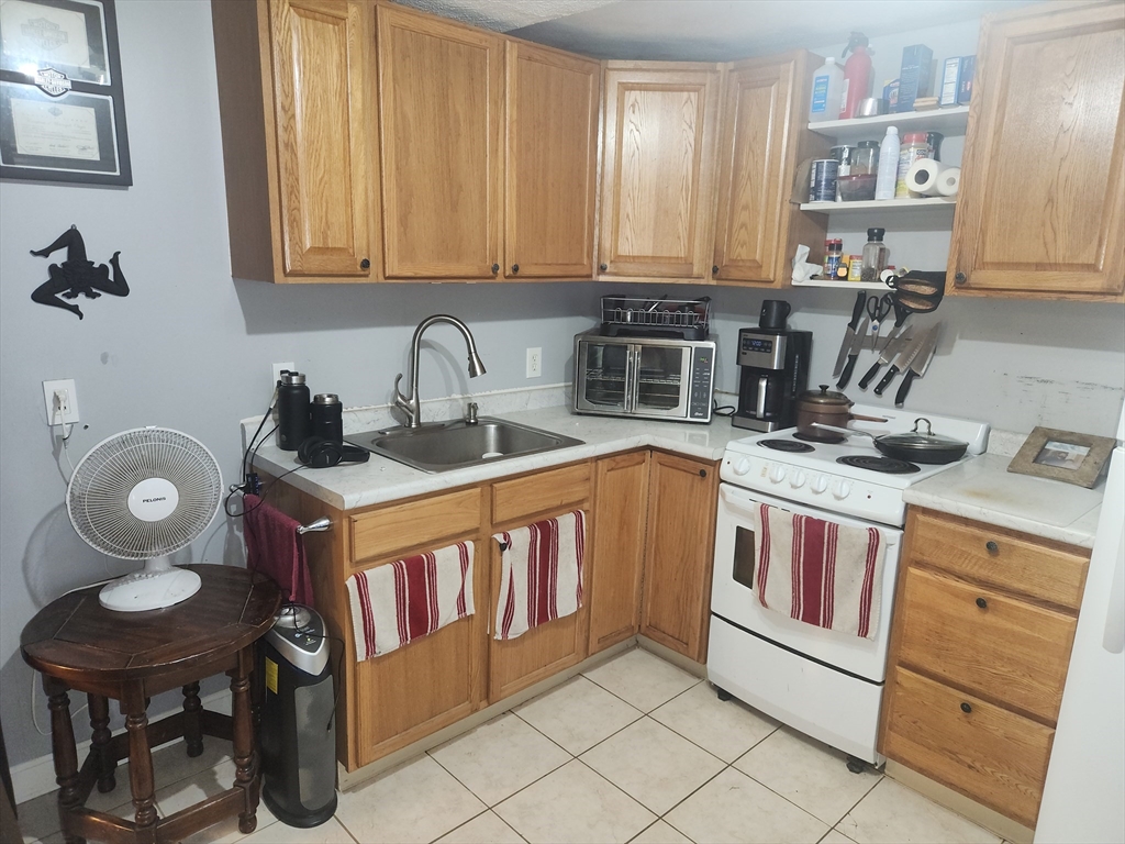 81 Cabot Street, Unit 1M Beverly, MA 01915 - Photo 5 of 13 a kitchen with a stove a sink and a cabinets