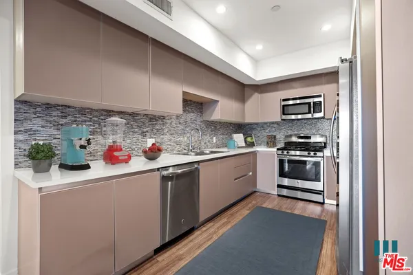 a kitchen with granite countertop a sink stainless steel appliances and cabinets