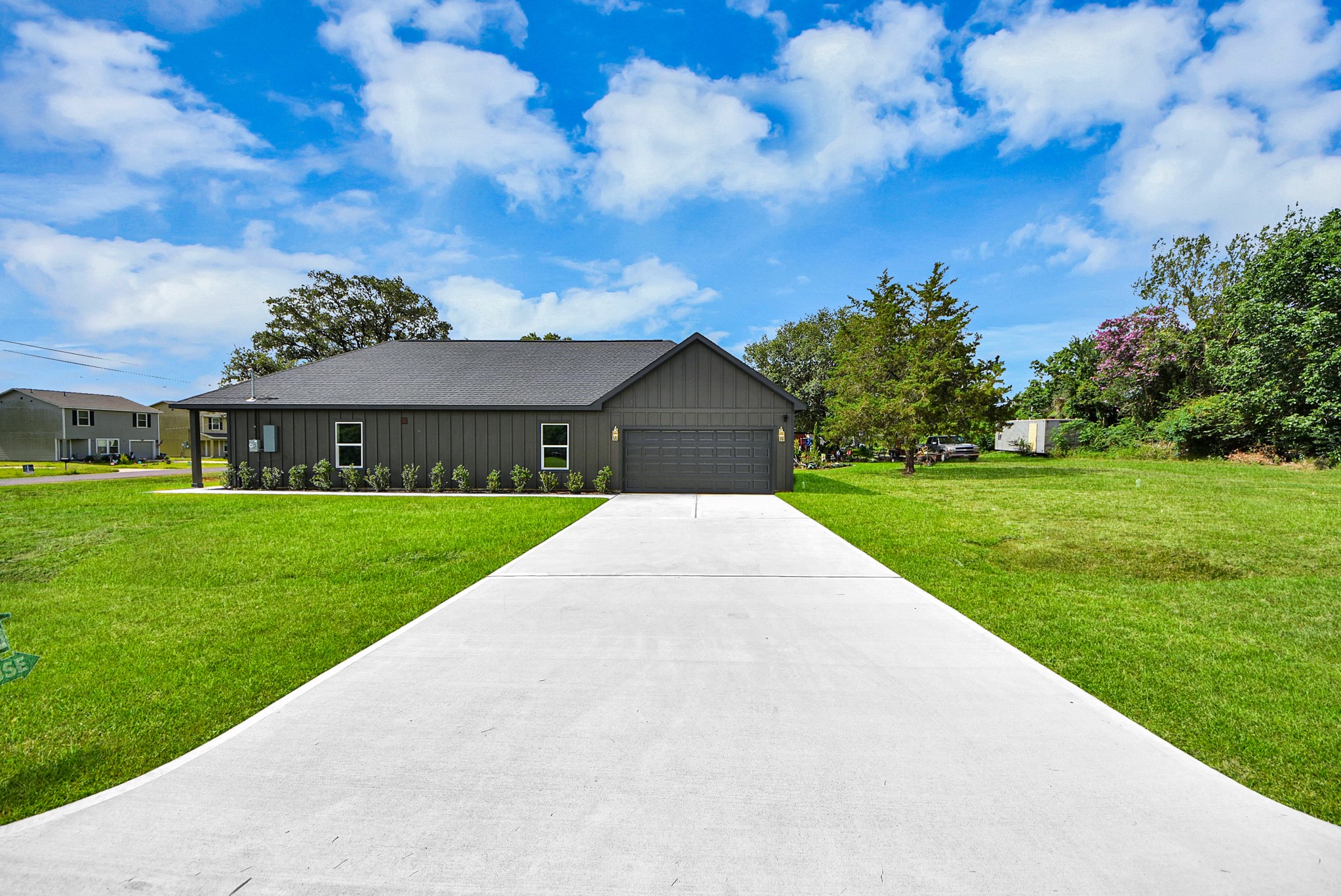 211 19th Street Hempstead, TX 77445 - Photo 1 of 32 Modern exterior with a long driveway and attached two-car garage.