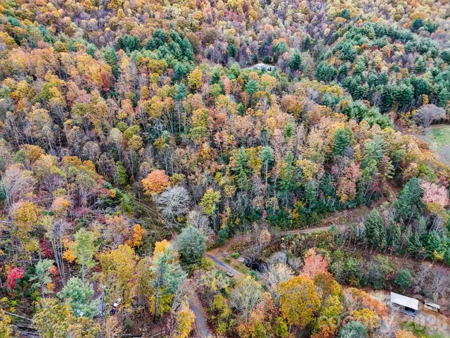 an aerial view of house with yard and mountain view in back
