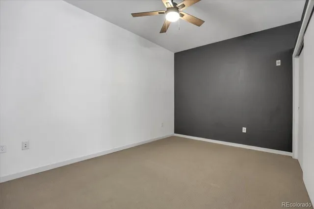 an empty room with chandelier fan