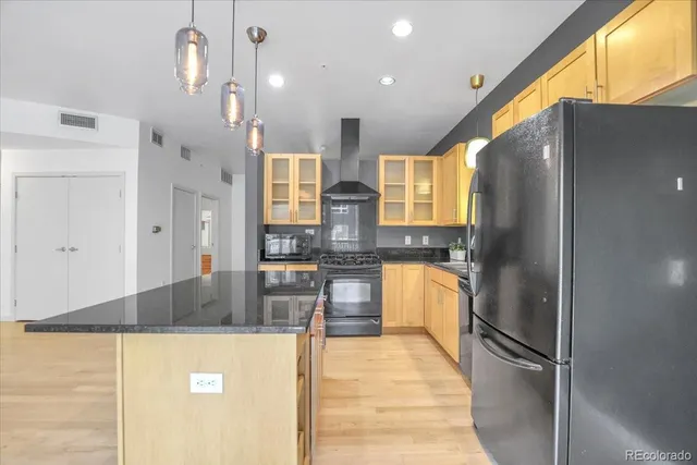 a kitchen with stainless steel appliances granite countertop a refrigerator a sink and a stove