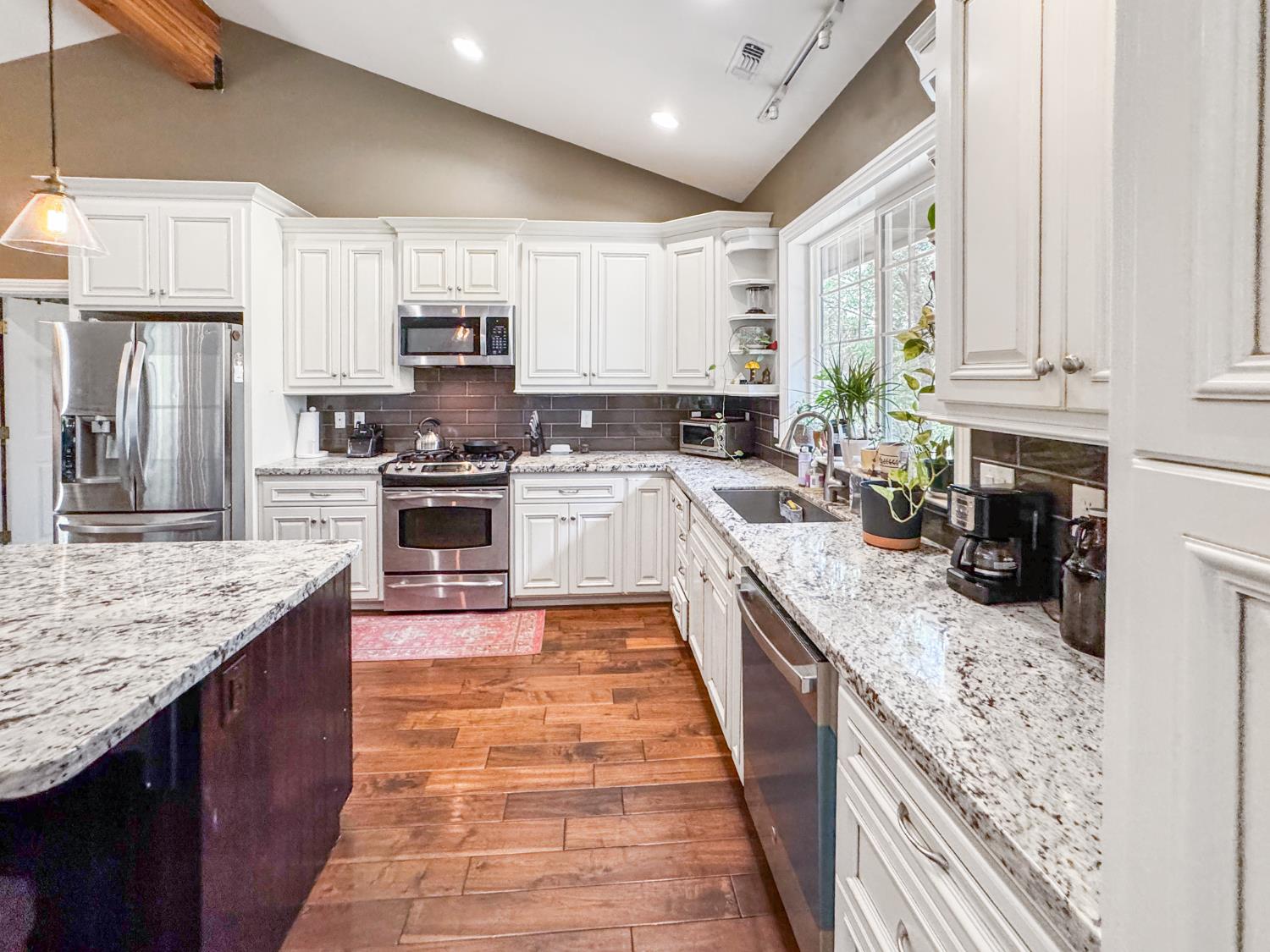 15655 Rough And Ready Highway Rough and Ready, CA 95975 - Photo 8 of 48 a large kitchen with stainless steel appliances granite countertop a stove top oven a sink dishwasher and wooden cabinets with wooden floor