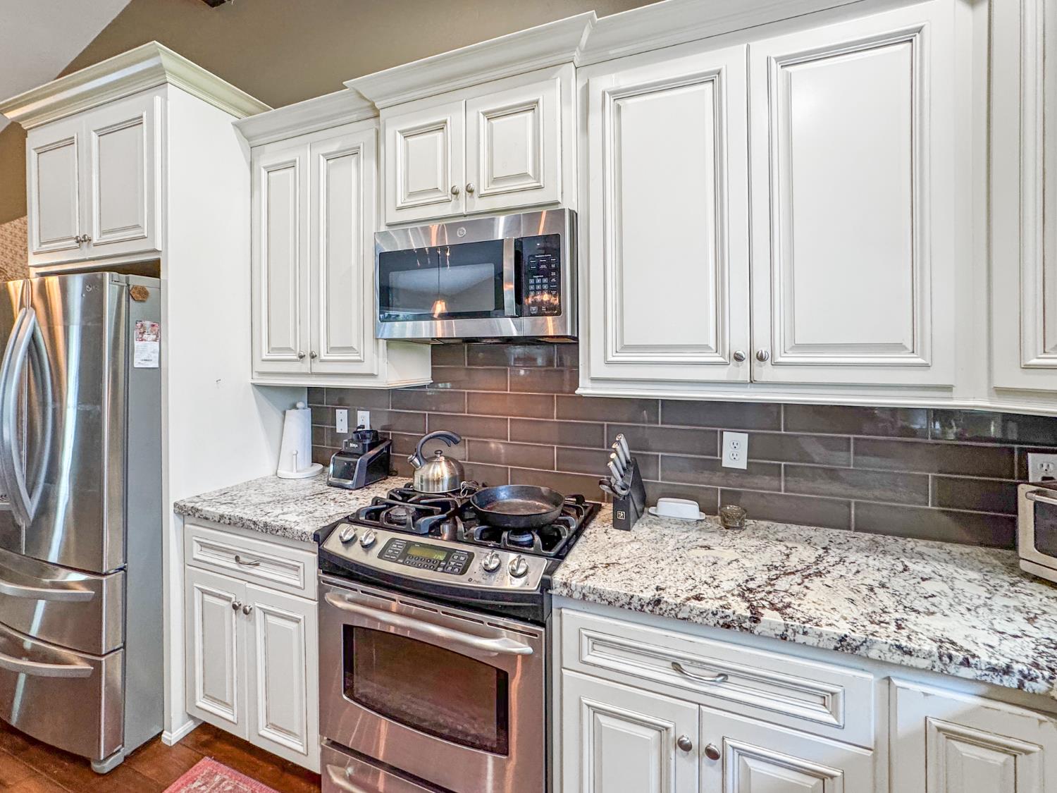 15655 Rough And Ready Highway Rough and Ready, CA 95975 - Photo 10 of 48 a kitchen with granite countertop white cabinets and stainless steel appliances
