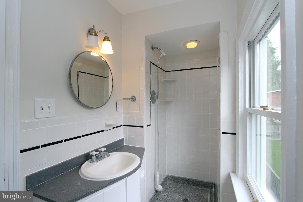 10022 Dallas Avenue Silver Spring, MD 20901 - Photo 21 of 30 a bathroom with a sink mirror and a shower