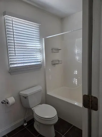 a bathroom with a toilet and a shower