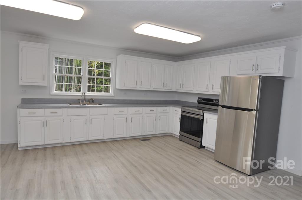 950 Hopps Road, Unit 10 Chester, SC 29706 - Photo 3 of 30 a kitchen with granite countertop white cabinets and stainless steel appliances