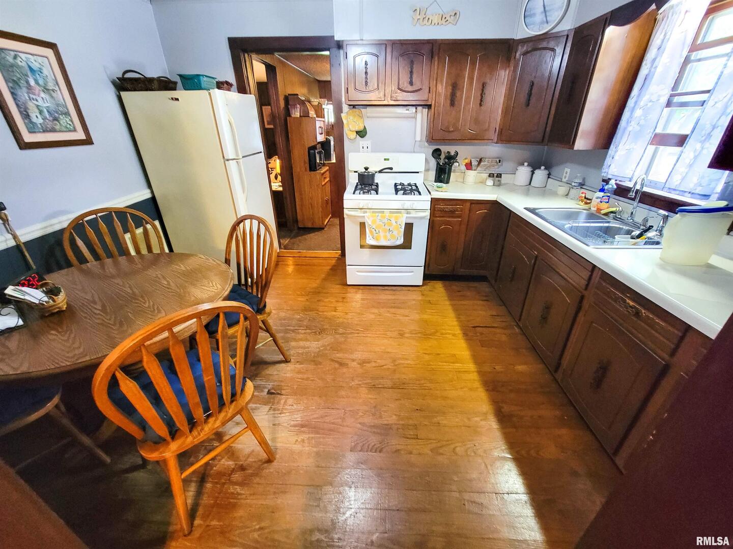 113 Mead Street Southwest Clay City, IL 62824 - Photo 24 of 61 a kitchen with stainless steel appliances granite countertop a refrigerator a stove a sink dishwasher and wooden cabinets with wooden floor