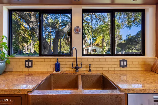 a bathroom with a granite countertop sink and large window