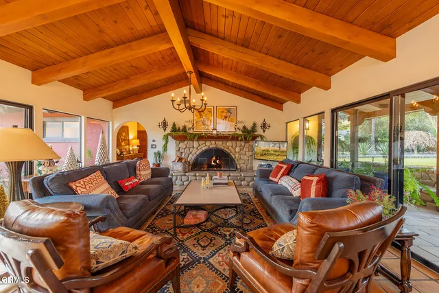 a living room with furniture a fireplace and a chandelier